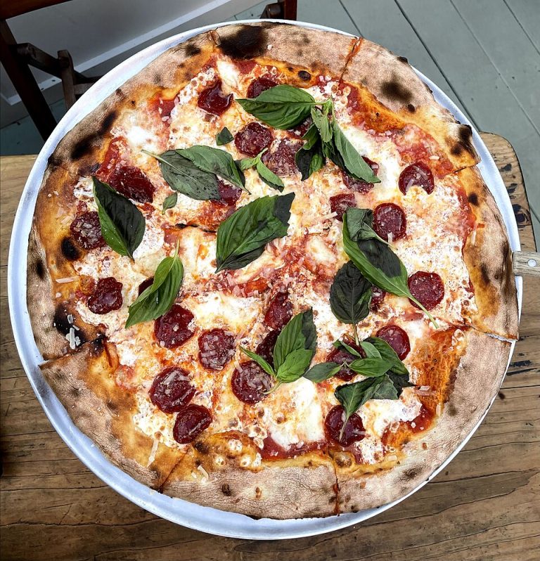 Pepperoni pizza with basil on a metal tray at Lucali in Brooklyn, photographed in June 2021.